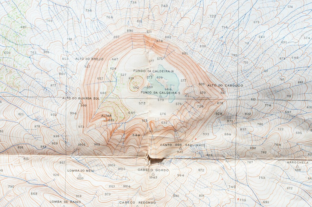 Old paper map spread on a table with a compass